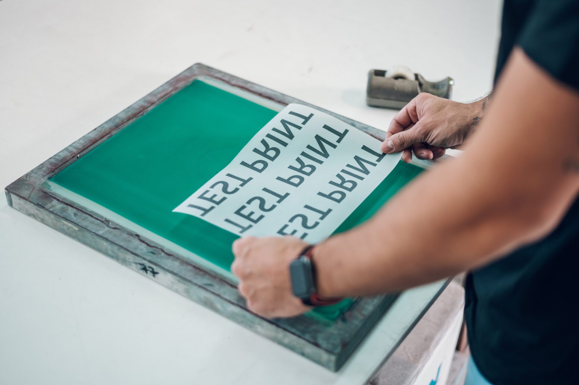 Male worker preparing screen printing film in workshop